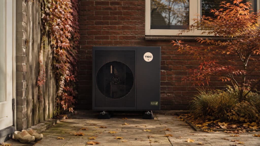 TEC HS10 hybride warmtepomp in Nederlandse achtertuin in de herfst, R290 buitenunit op trillingsdempers